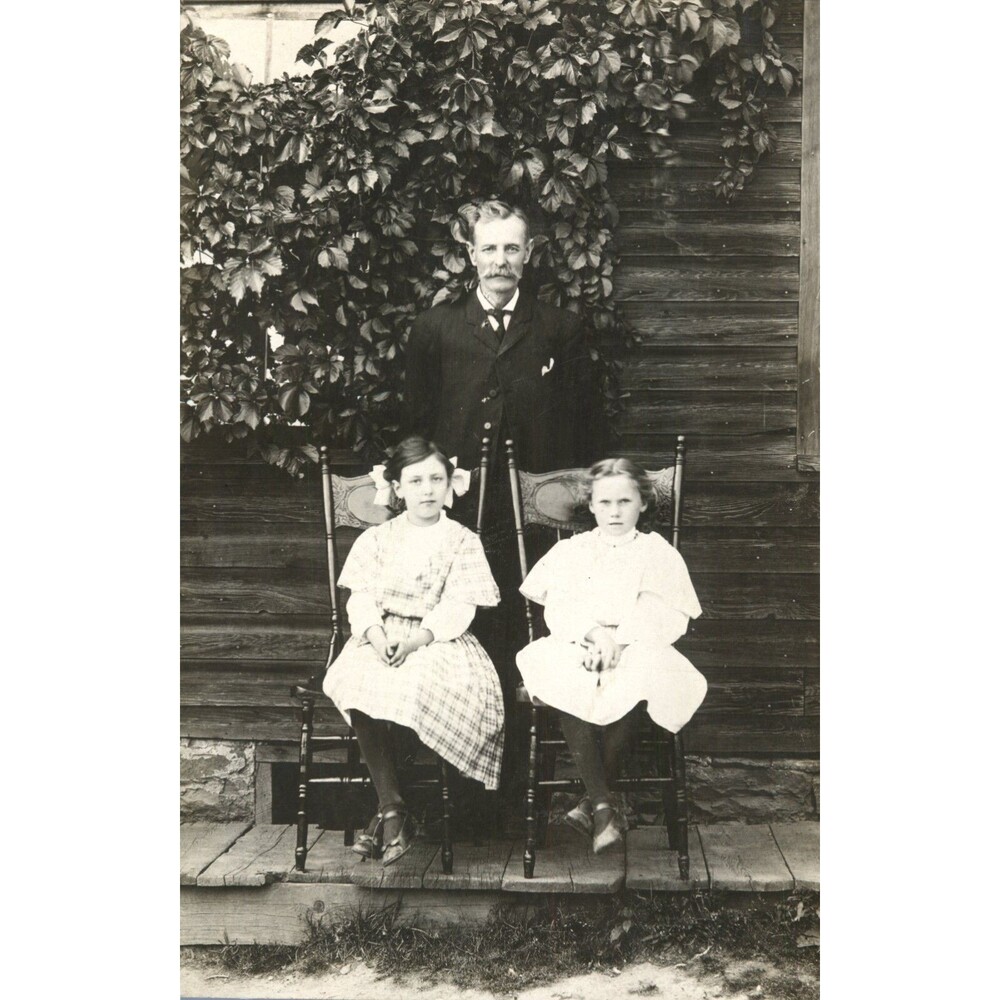 Vtg 1900's RPPC Father Posing With Two Daughters Sitting In Chair Outside